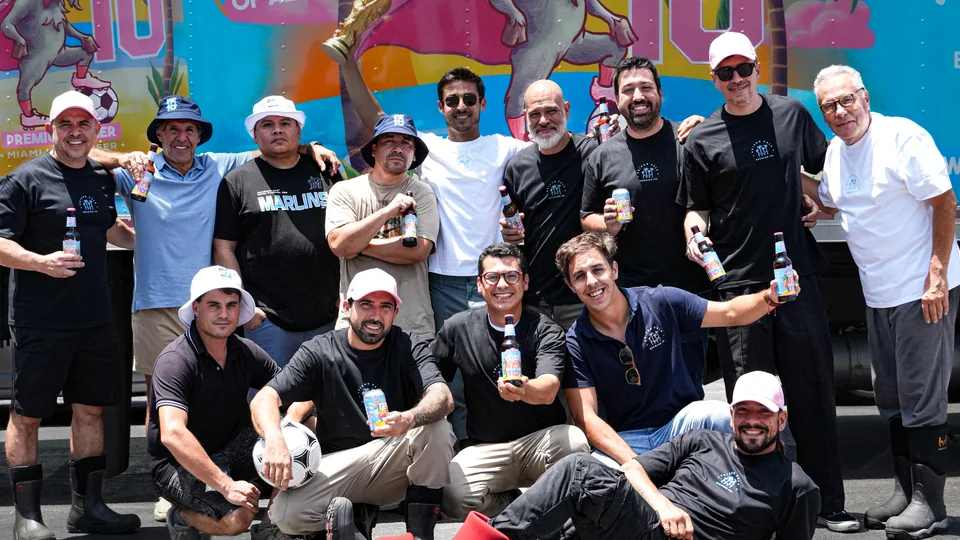 The Prison Pals team together in front of the GOAT10 mural in Miami.